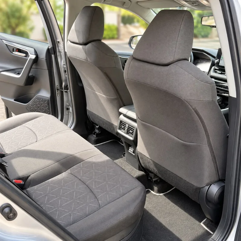Habitacle du Toyota RAV4 Hybride de Marc, vu depuis la porte arrière, avec banquette en tissu et espace pour les passagers